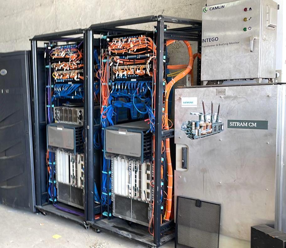Two equipment racks holding Cisco chassis switches with orange and blue cabling dressed to vertical managers